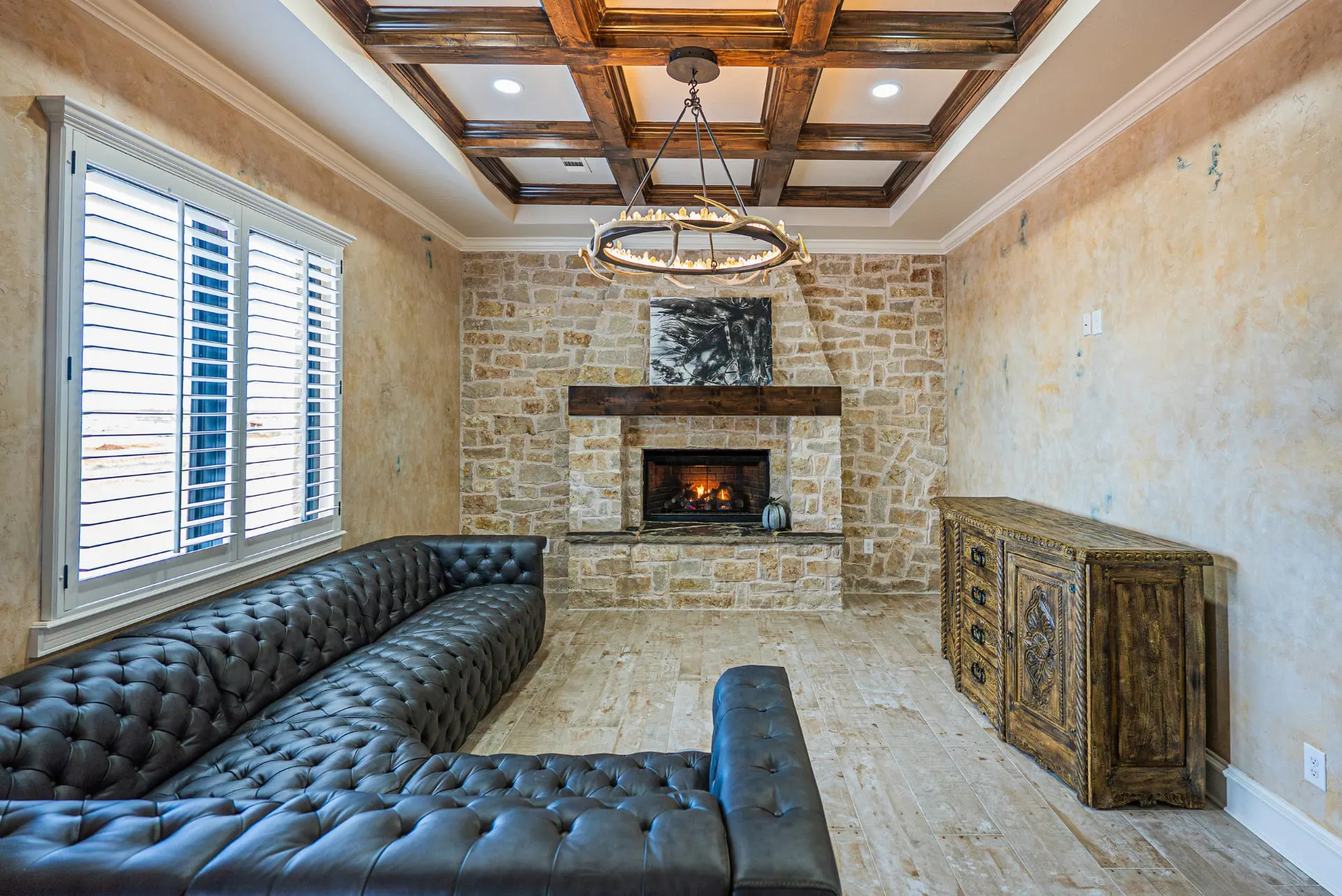 Living room at 5 Prairie Ln with stone fireplace and coffered wood ceiling