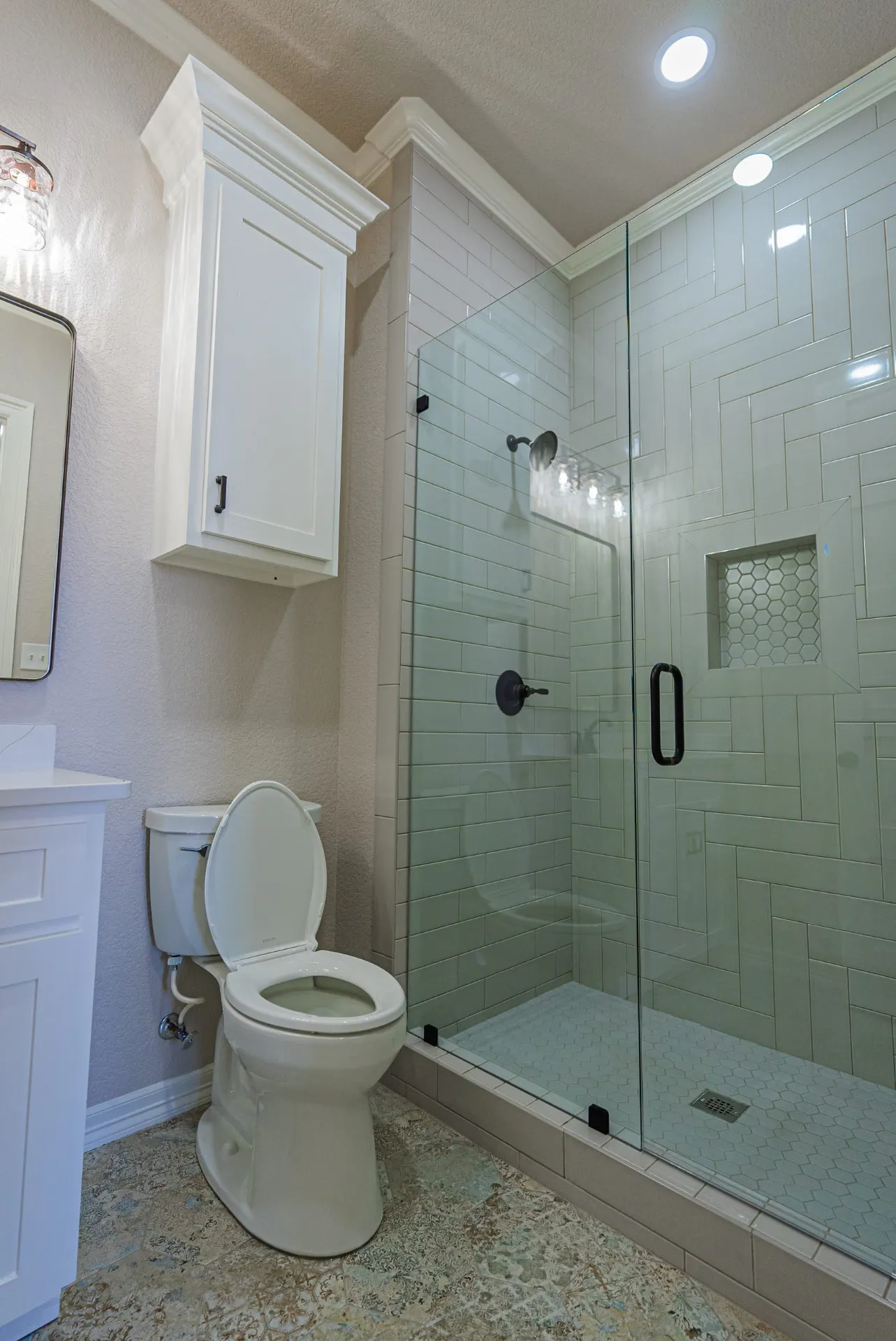 Bathroom at 1602 NW 12th St with sage-green herringbone subway tile shower, hexagon mosaic niche and black fixtures