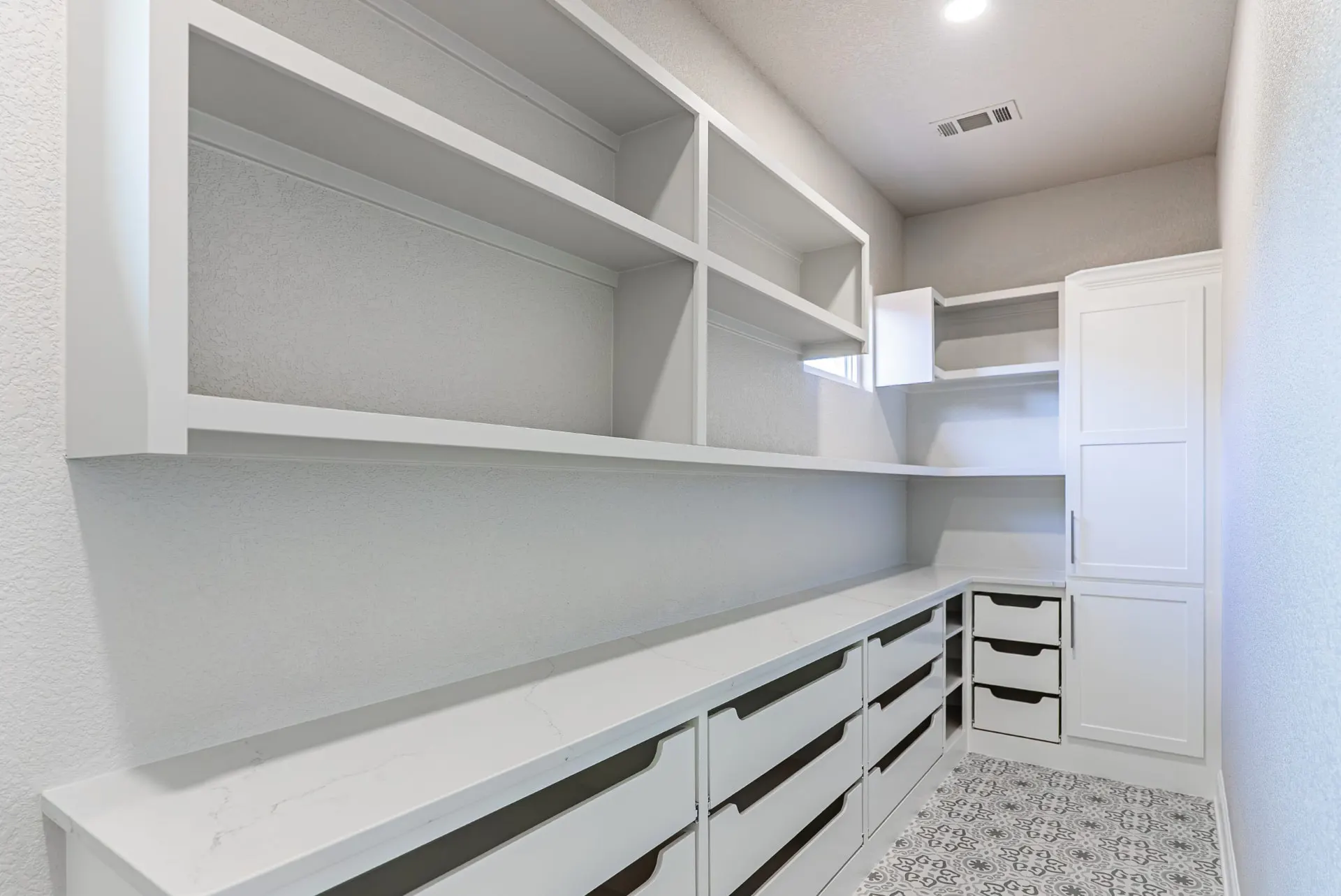 Walk-in pantry with quartz counter, open shelving and patterned cement-look tile at 27 Santiago Mission Dr