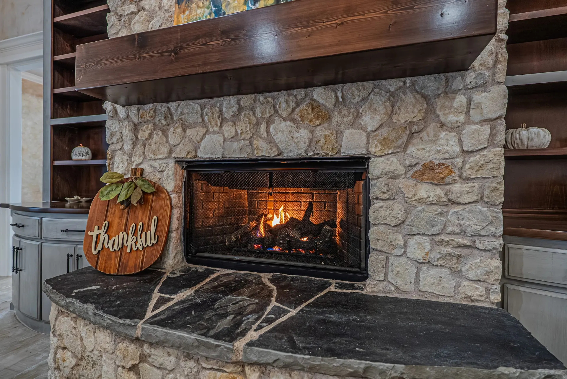 Stacked-stone fireplace close-up with lit fire at 5 Prairie Ln