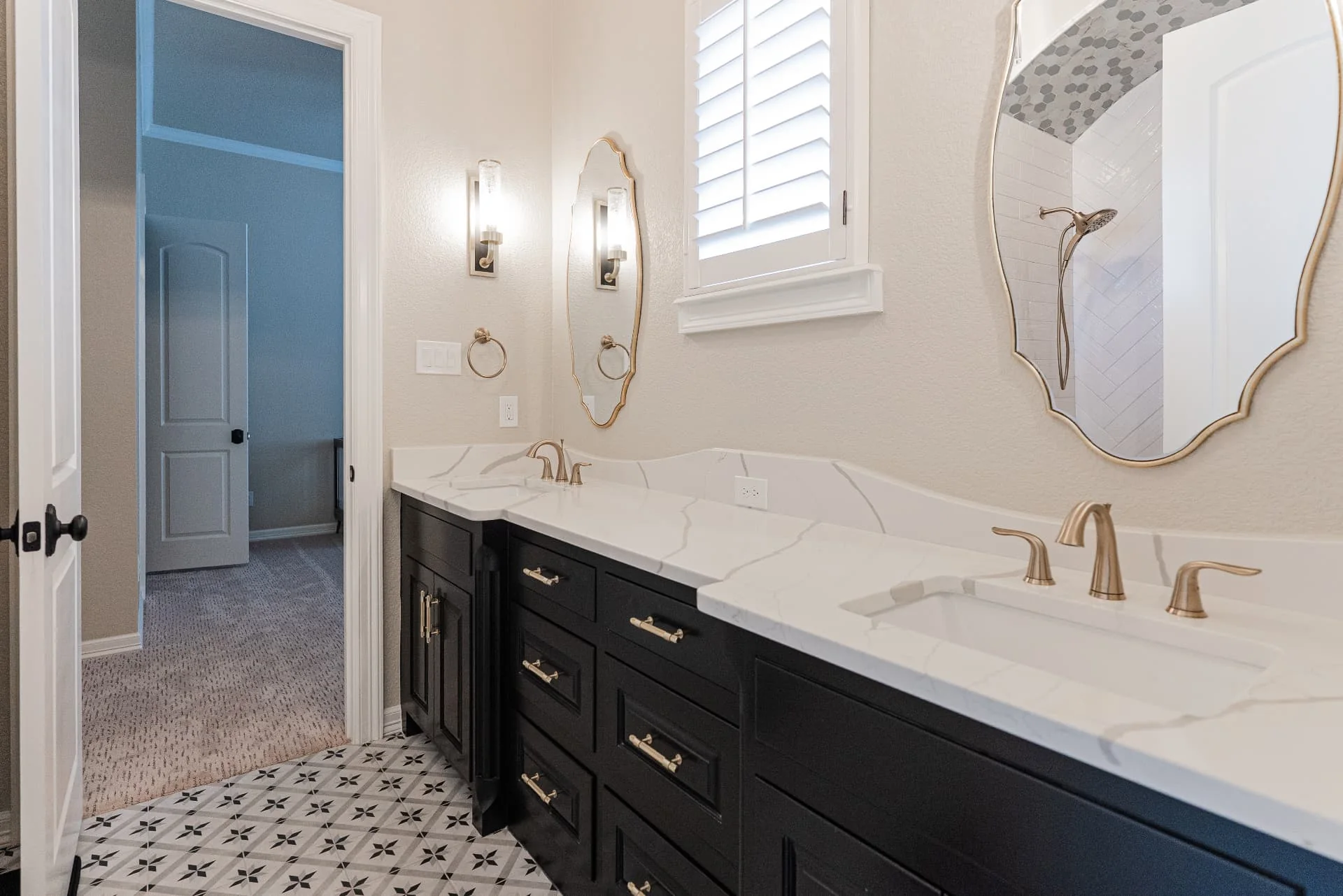 Bathroom vanity with dark cabinetry and round mirrors at The Flores Estate