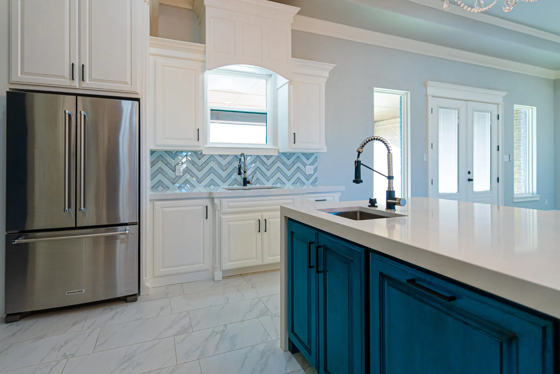 Kitchen at 1511 NW 12th St with stainless French-door refrigerator, teal island and herringbone backsplash