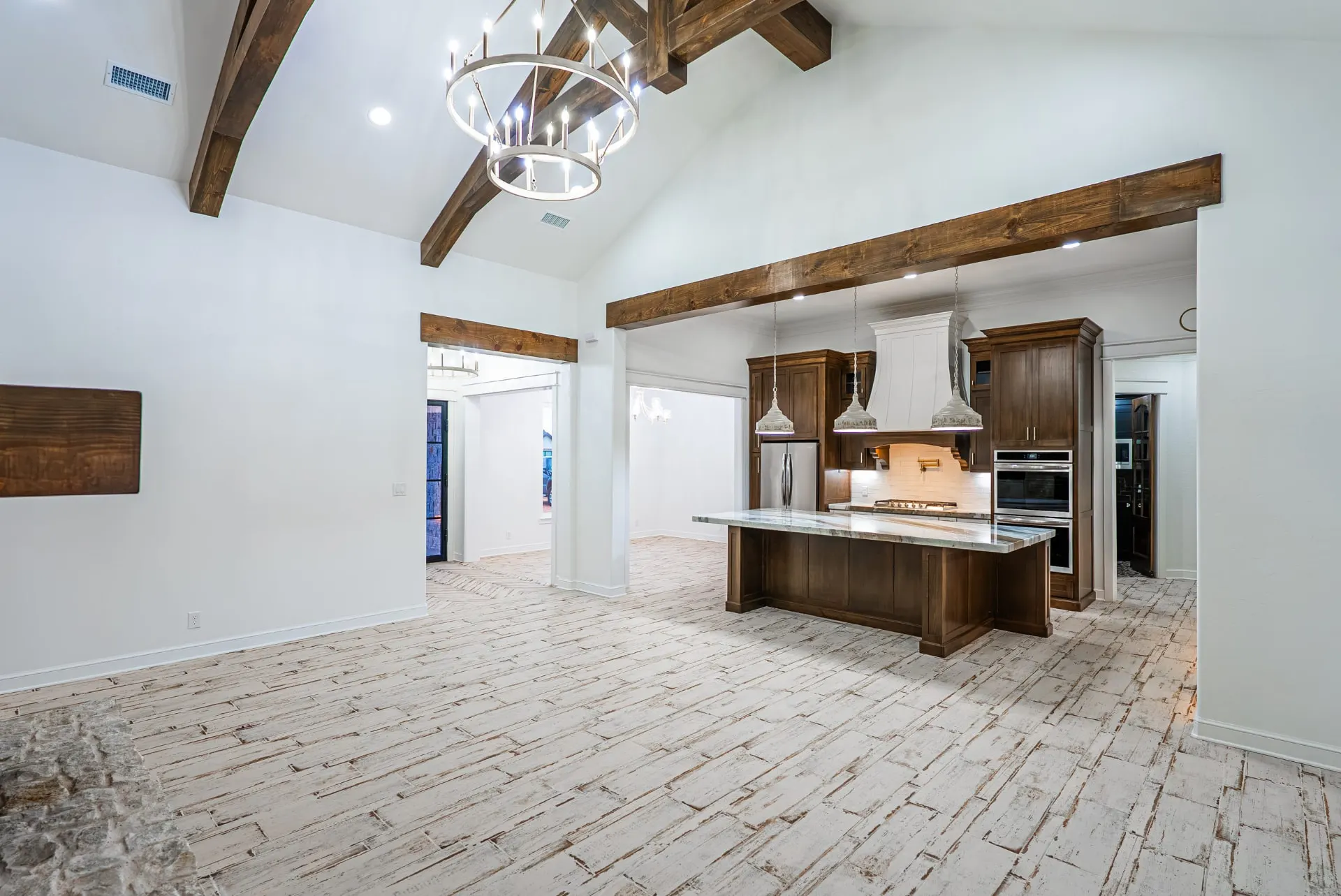 Open kitchen and great room at 1607 NW 12th St under exposed timber trusses