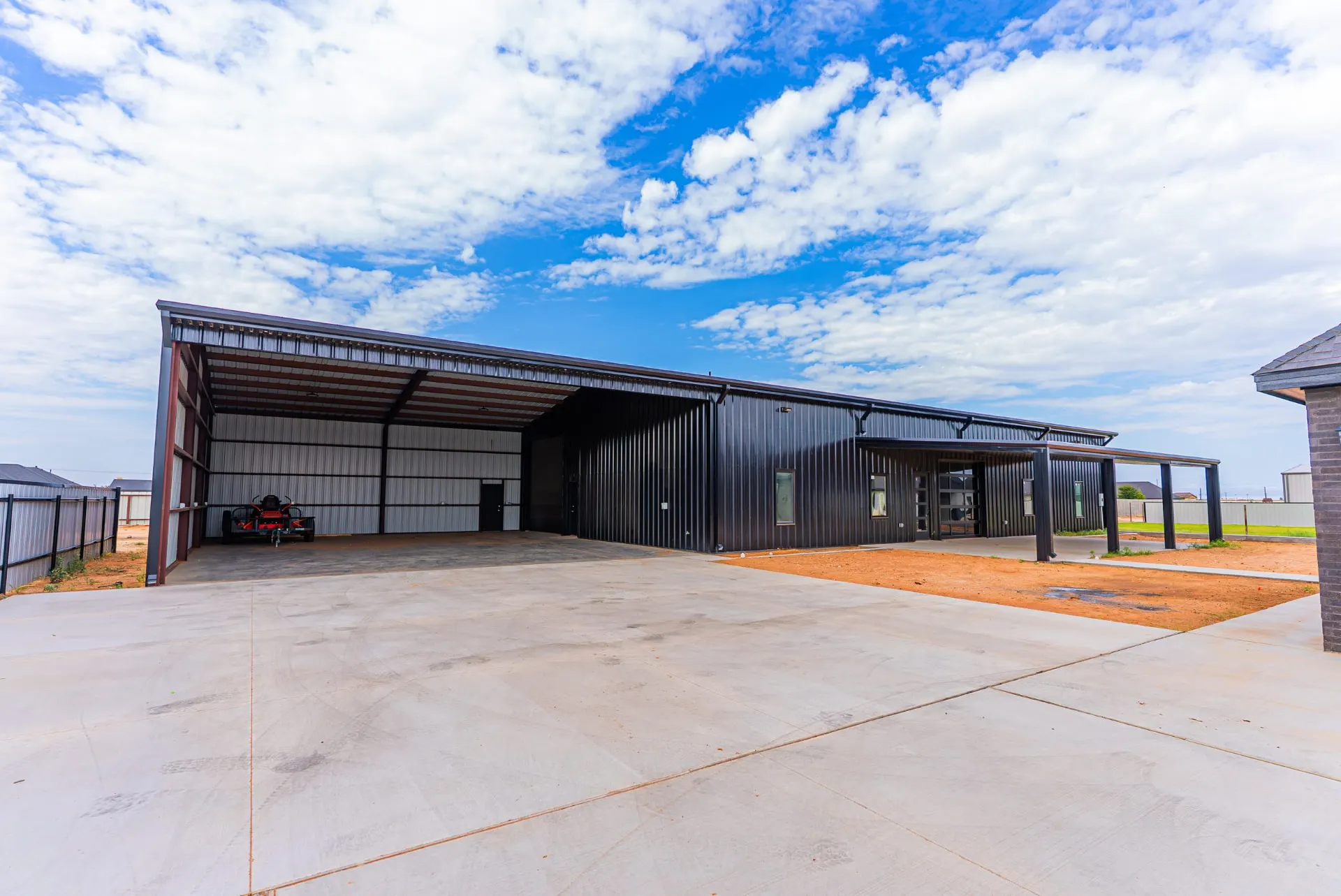 Black steel shop building with an open equipment bay at 1607 NW 12th St