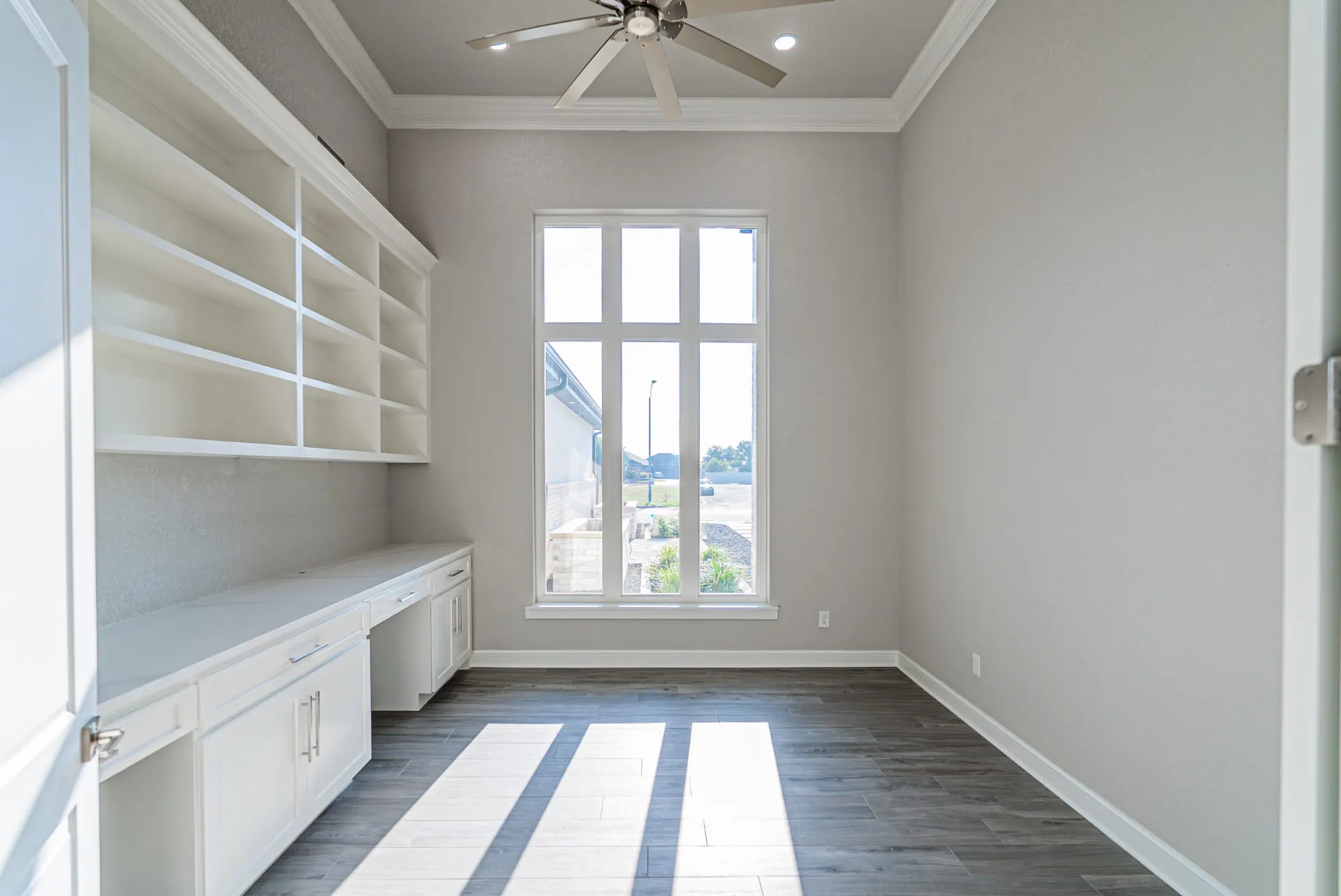 Study at 27 Santiago Mission Dr with built-in desk cabinetry, open shelving and a tall window