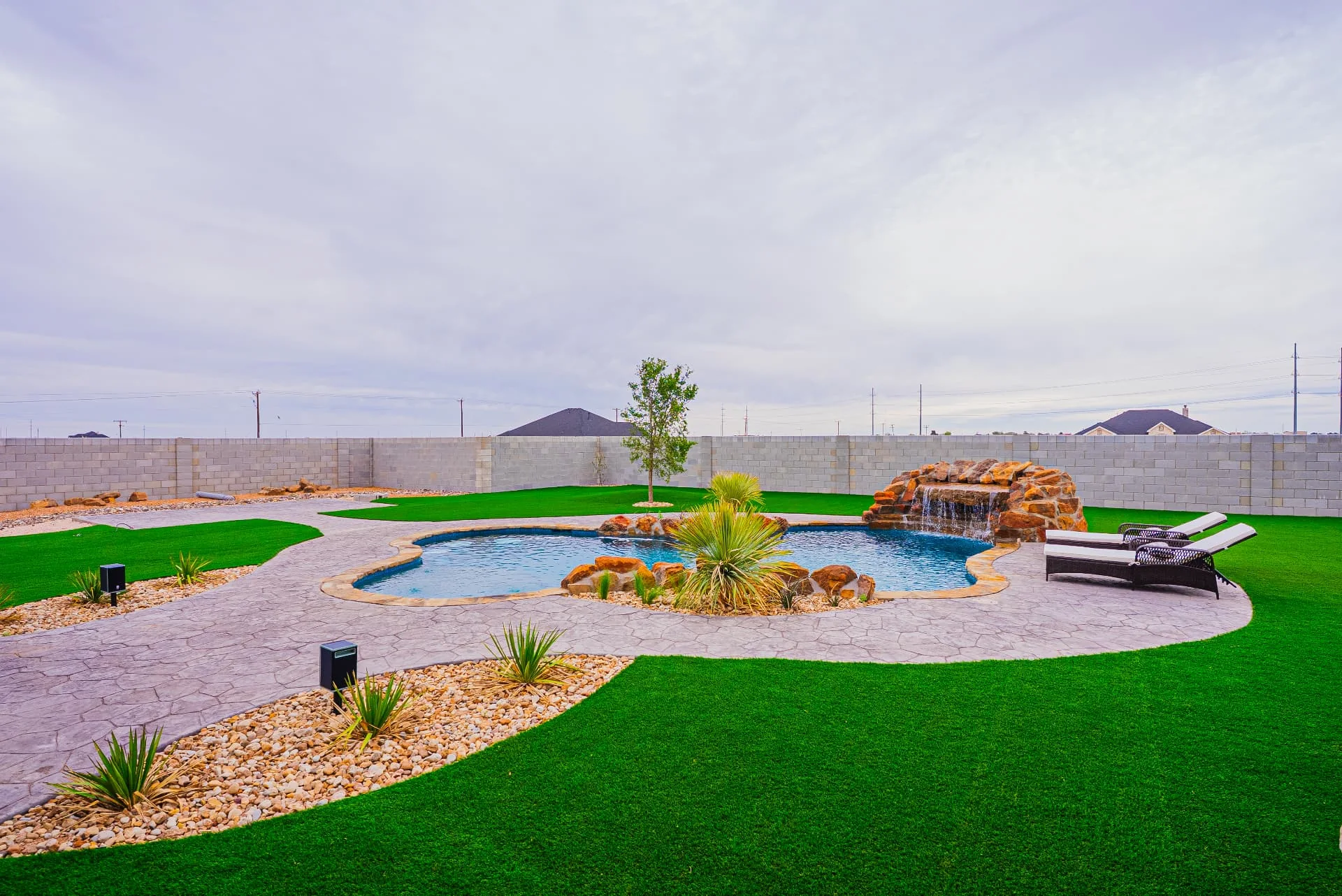 Backyard pool and landscaped lawn at The Flores Estate
