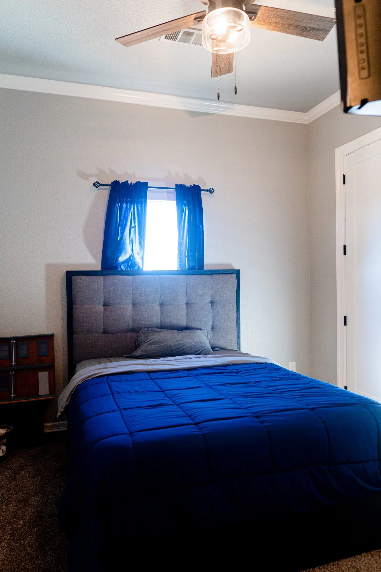 Same bedroom at 8821 Shawn Dr centered on the bed, with a ceiling fan and a doorway to the hall