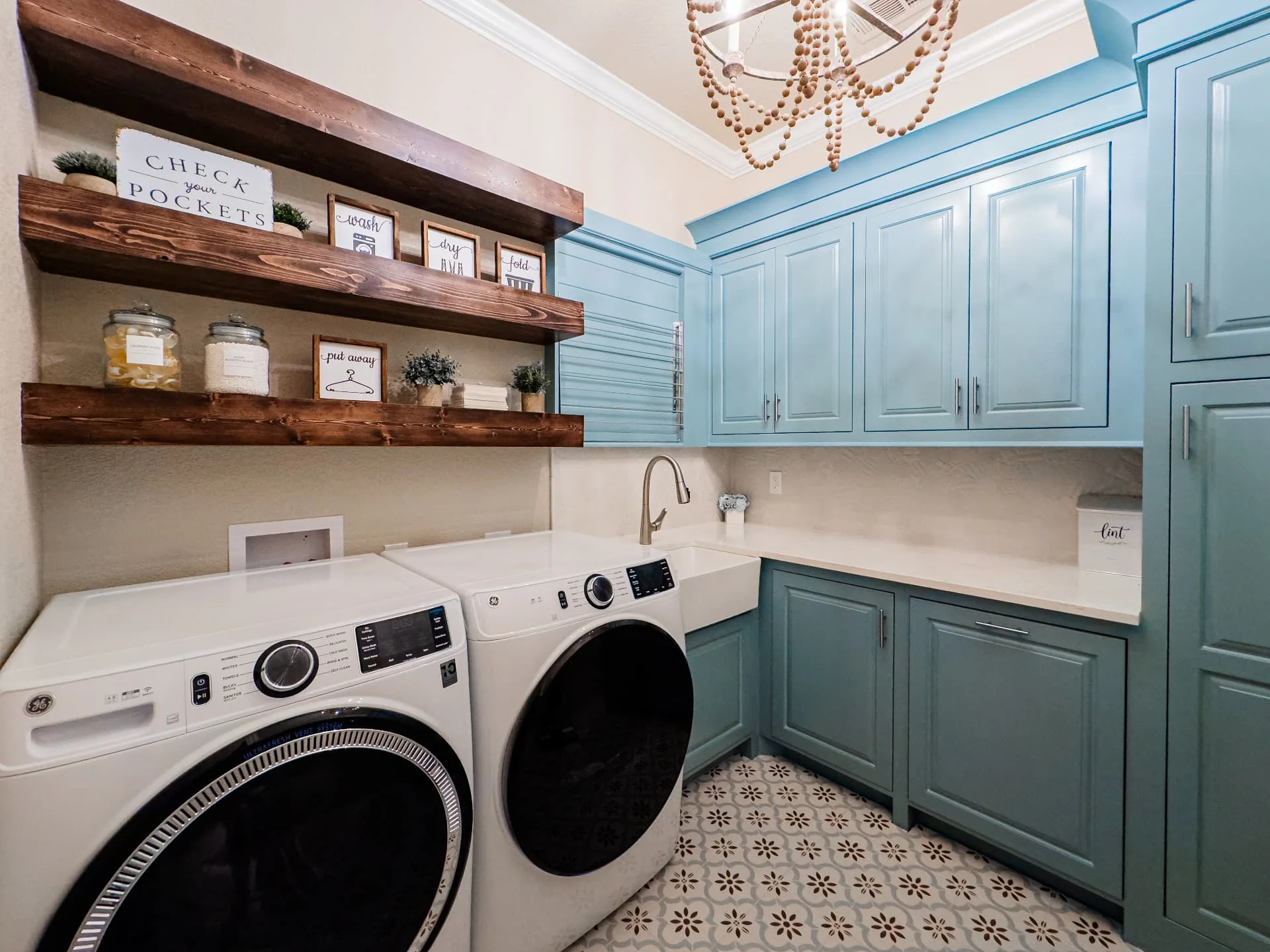 Laundry room with blue cabinetry and patterned floor at The Flores Estate