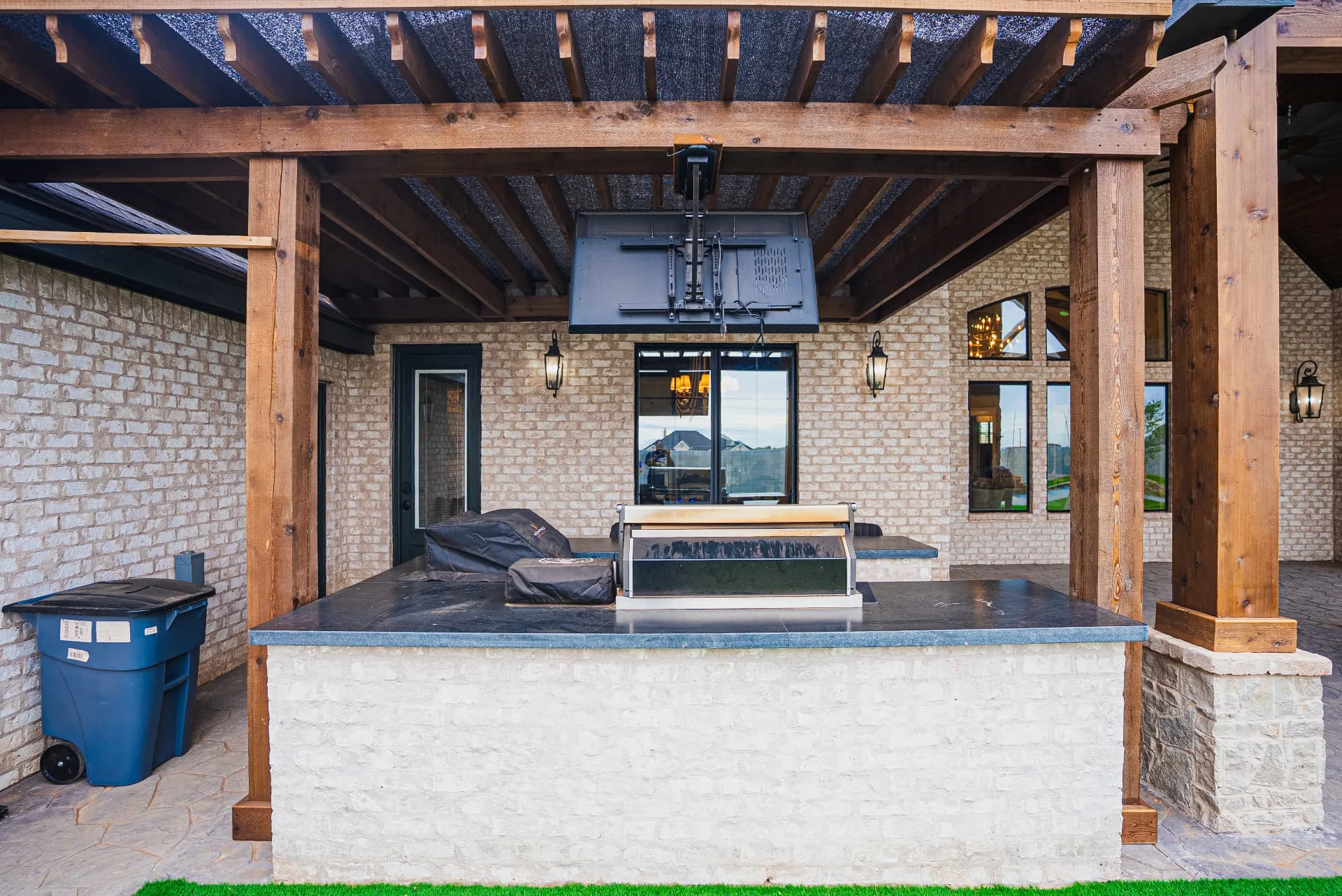Outdoor cooking area beneath the wood pergola at The Flores Estate